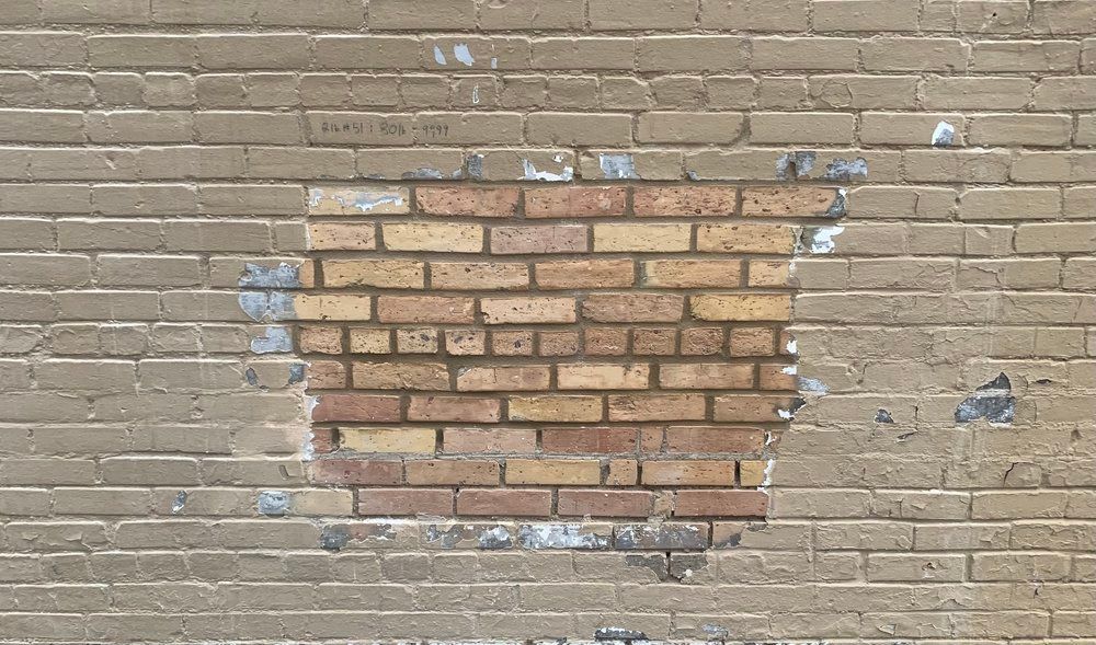 A brick wall with a hole in the middle of it