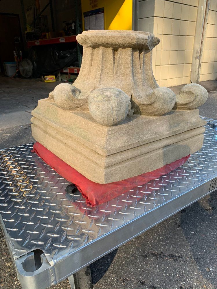 A large stone sculpture is sitting on top of a metal cart.