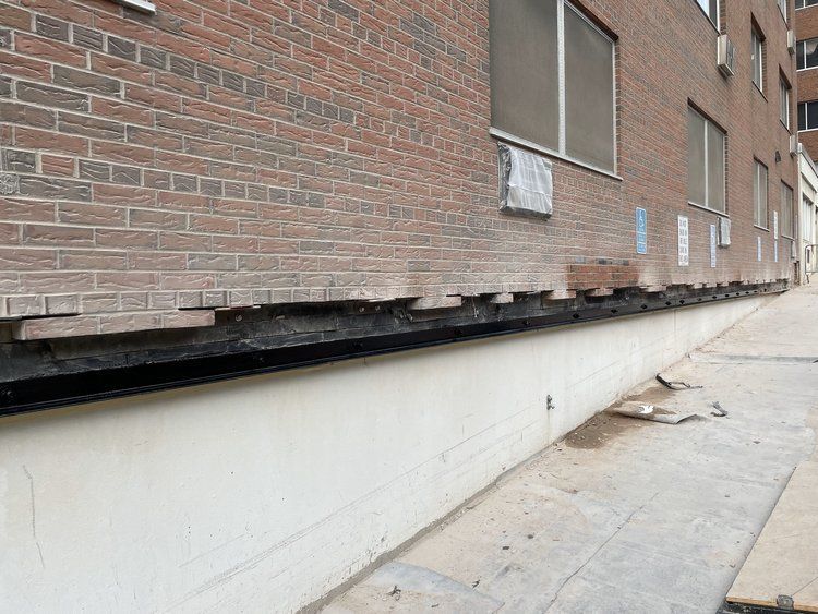 A brick building with a lot of windows is being moved.