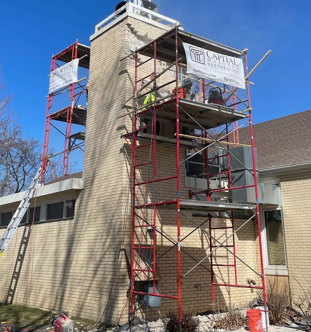 A large brick building is on the corner of a city street.