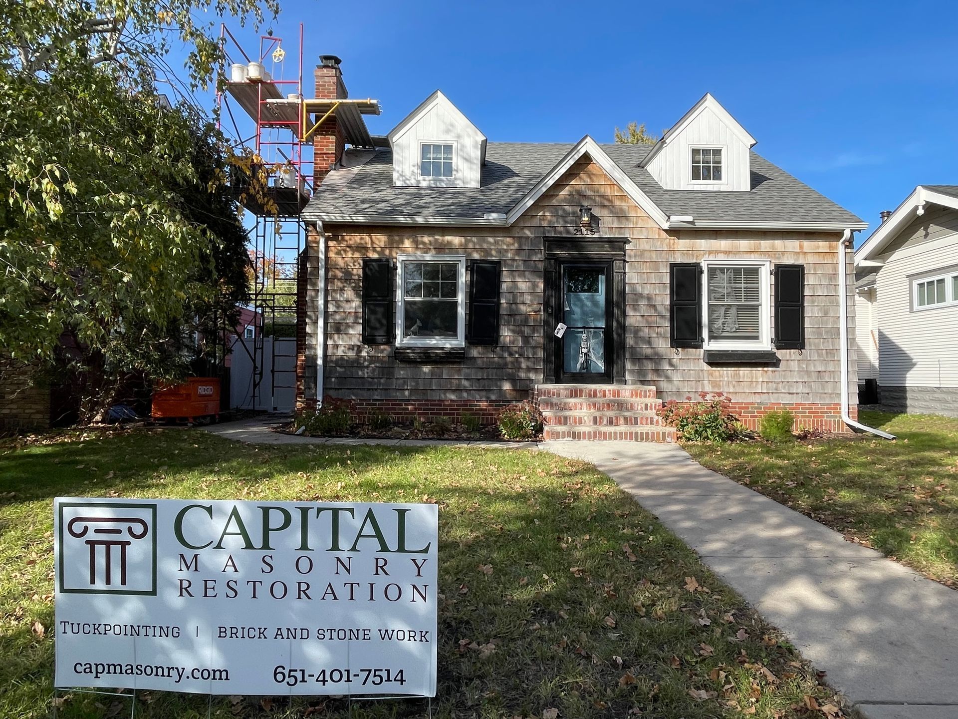 A house with a sign in front of it that says capital masonry restoration