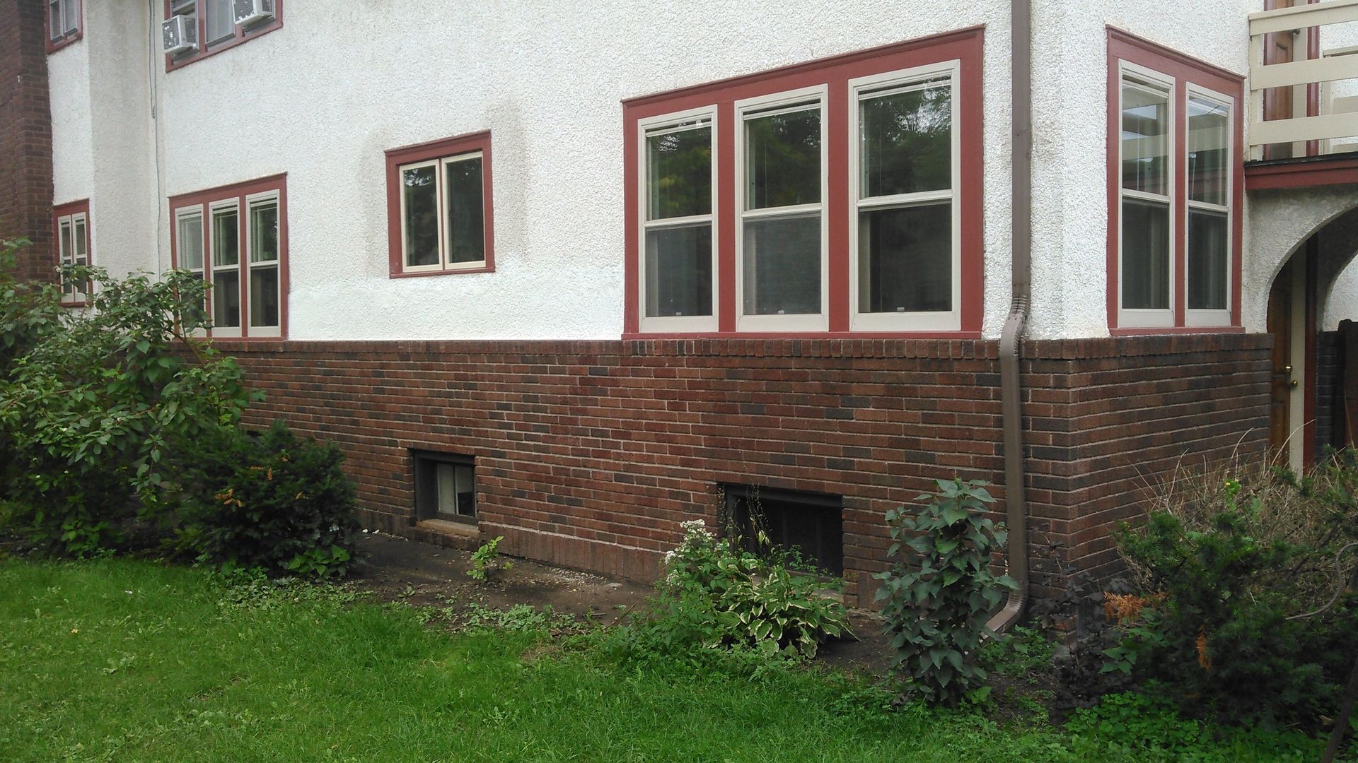 A white house with red trim and a lot of windows