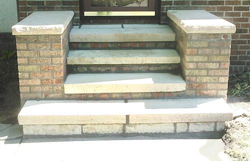 A set of stone steps leading up to a brick door