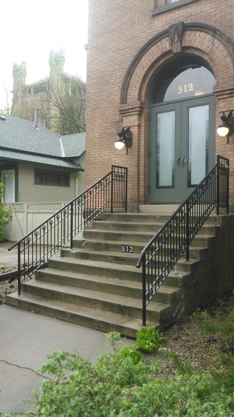 A brick building with stairs leading up to the front door
