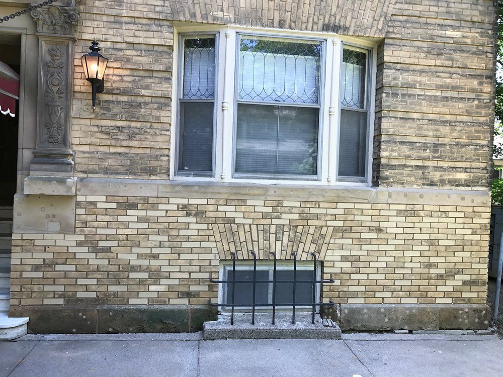 A brick building with a window and a lamp on the side
