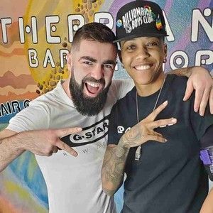 A man with a beard and a woman with a hat are posing for a picture.