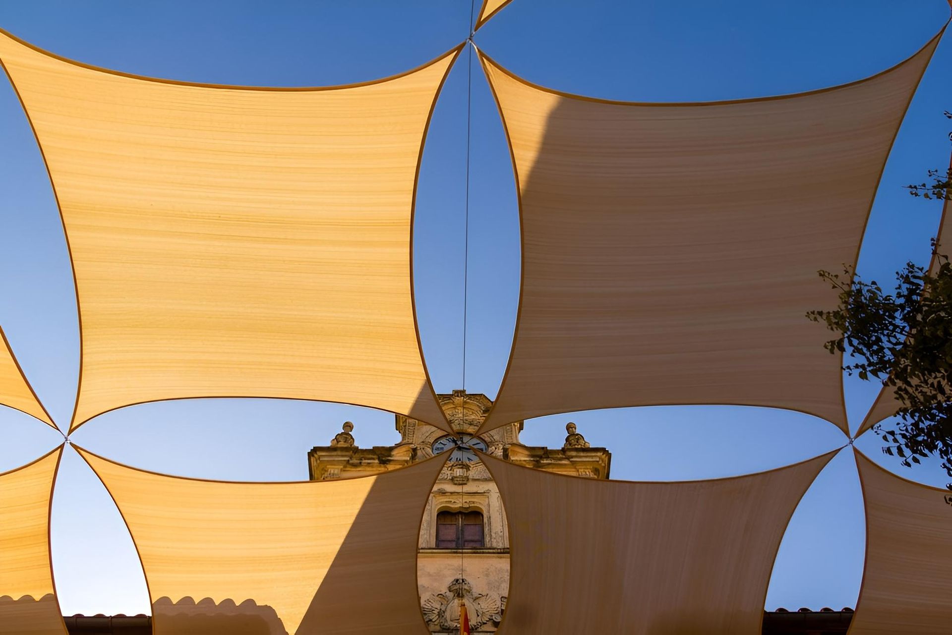 A Large Umbrella Is Hanging from The Side of A Building — Jon Wilson Canvas & Shade in Nambucca Heads, NSW