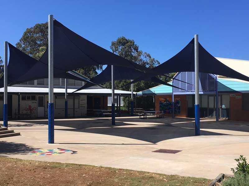 A Group of Umbrellas Are Sitting in Front of A Building — Jon Wilson Canvas & Shade in Coffs Harbour, NSW