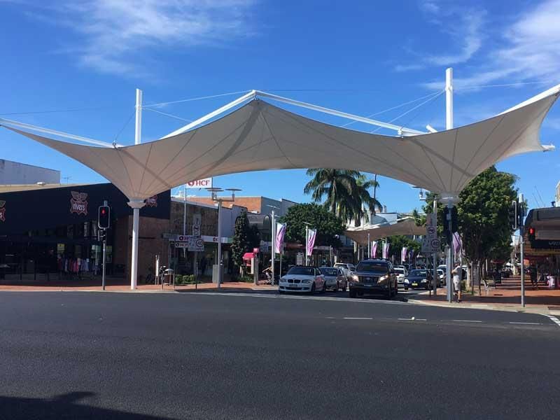 A Large White Umbrella Is Hanging Over an Intersection — Jon Wilson Canvas & Shade in Coffs Harbour, NSW