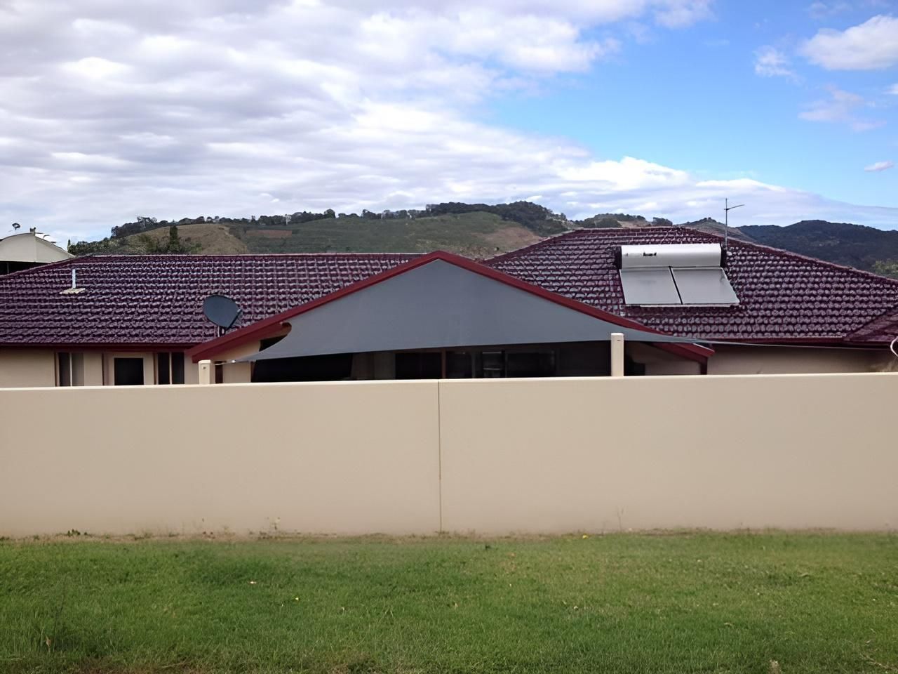 A House with A Purple Roof and A Fence in Front of It — Jon Wilson Canvas & Shade in Coffs Harbour, NSW