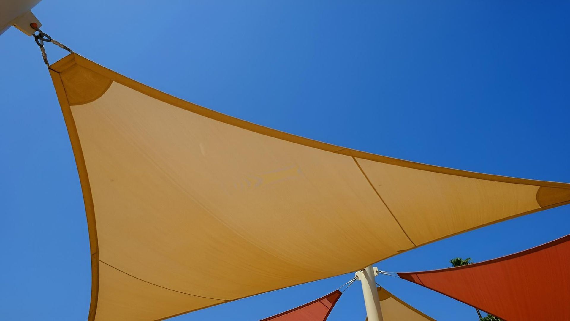 A Group of Triangle Shaped Umbrellas Against a Blue Sky — Jon Wilson Canvas & Shade in Coffs Harbour, NSW