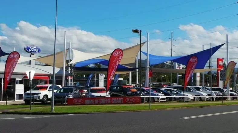 A Row of Cars Are Parked in Front of A Car Dealership — Jon Wilson Canvas & Shade in Coffs Harbour, NSW