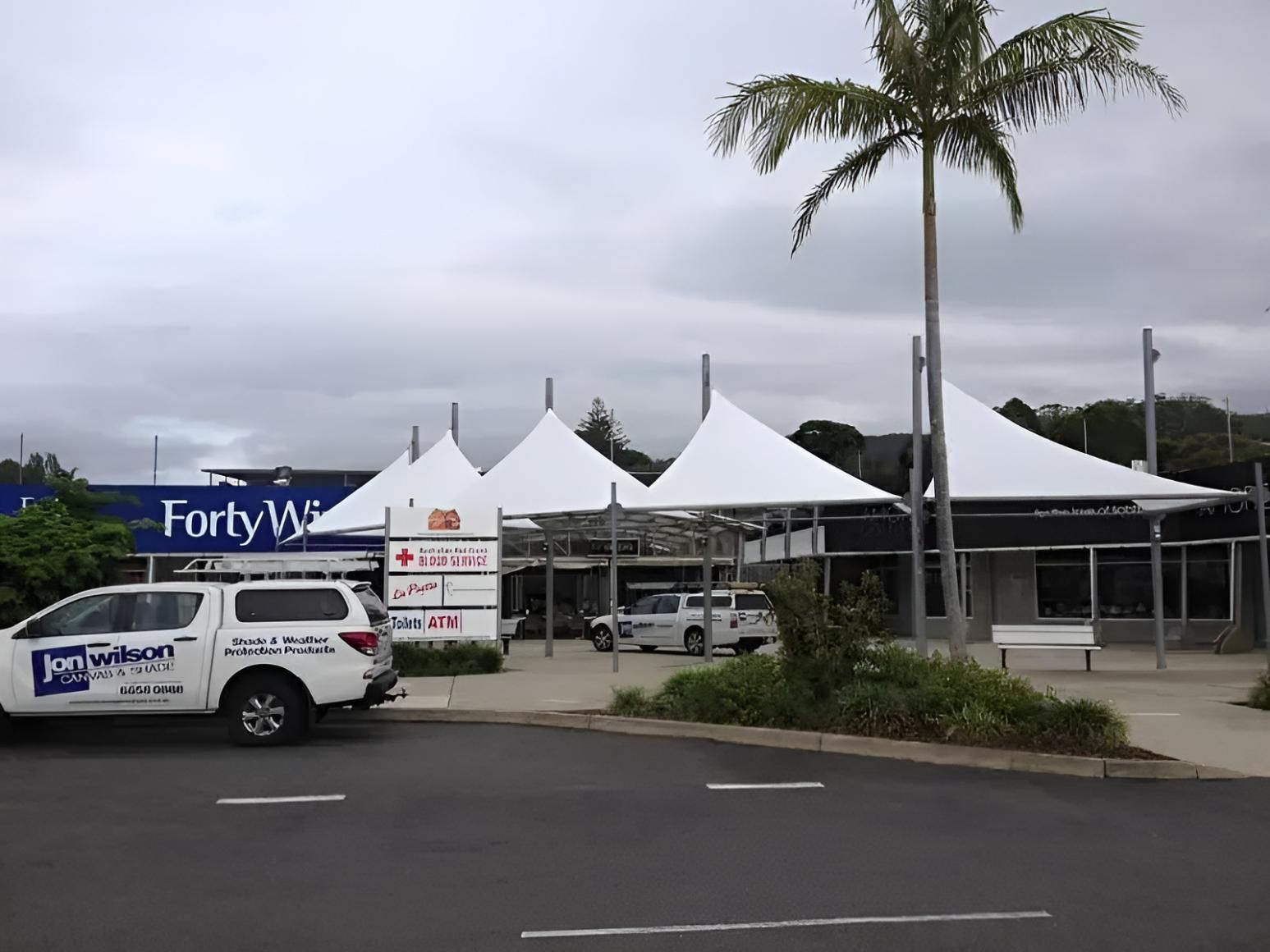 A White Truck Is Parked in Front of A Store Called Forty Winks — Jon Wilson Canvas & Shade in Coffs Harbour, NSW