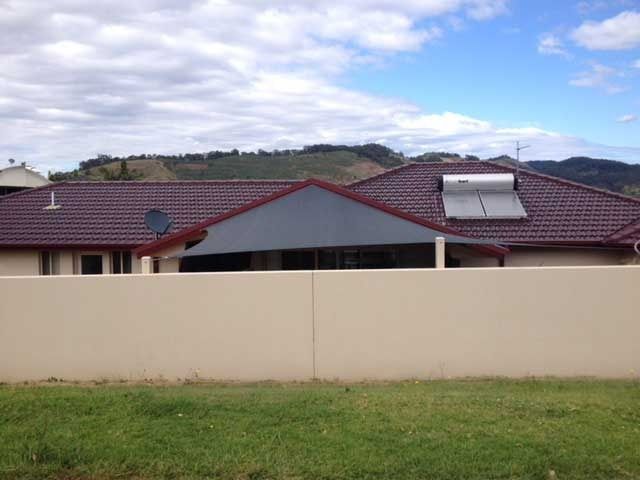 A House with A Roof and A Fence in Front of It — Jon Wilson Canvas & Shade in Coffs Harbour, NSW