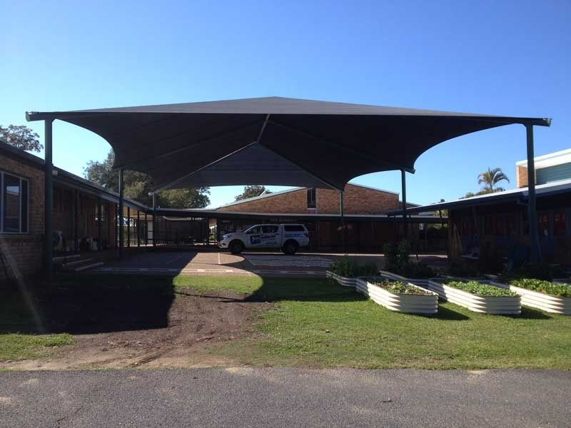 A Car Is Parked Under an Umbrella in Front of A House — Jon Wilson Canvas & Shade in Coffs Harbour, NSW