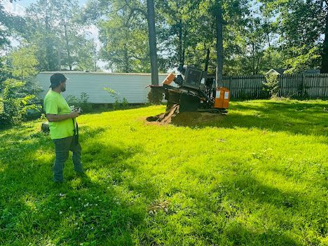 A man is standing in a grassy field next to a machine.
