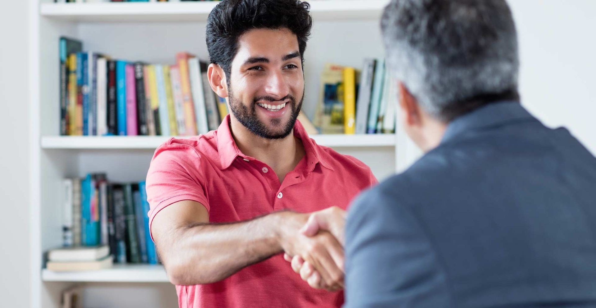 Two men are shaking hands in front of a bookshelf. Articulating Your Major: How to Communicate Your Interests to Attending Colleges