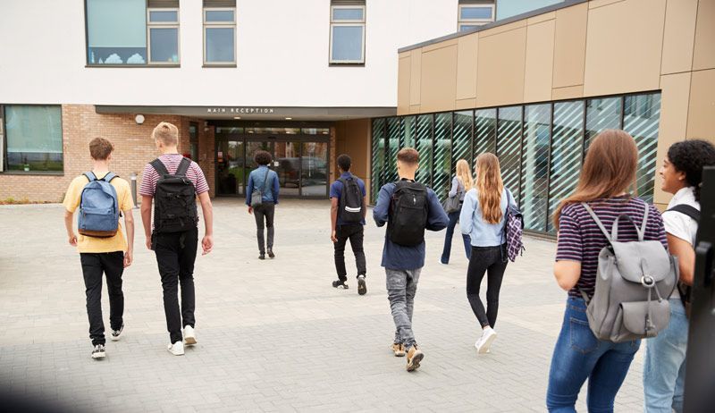 A group of students is walking towards a school building, Navigating College Fairs: A Guide for Fir