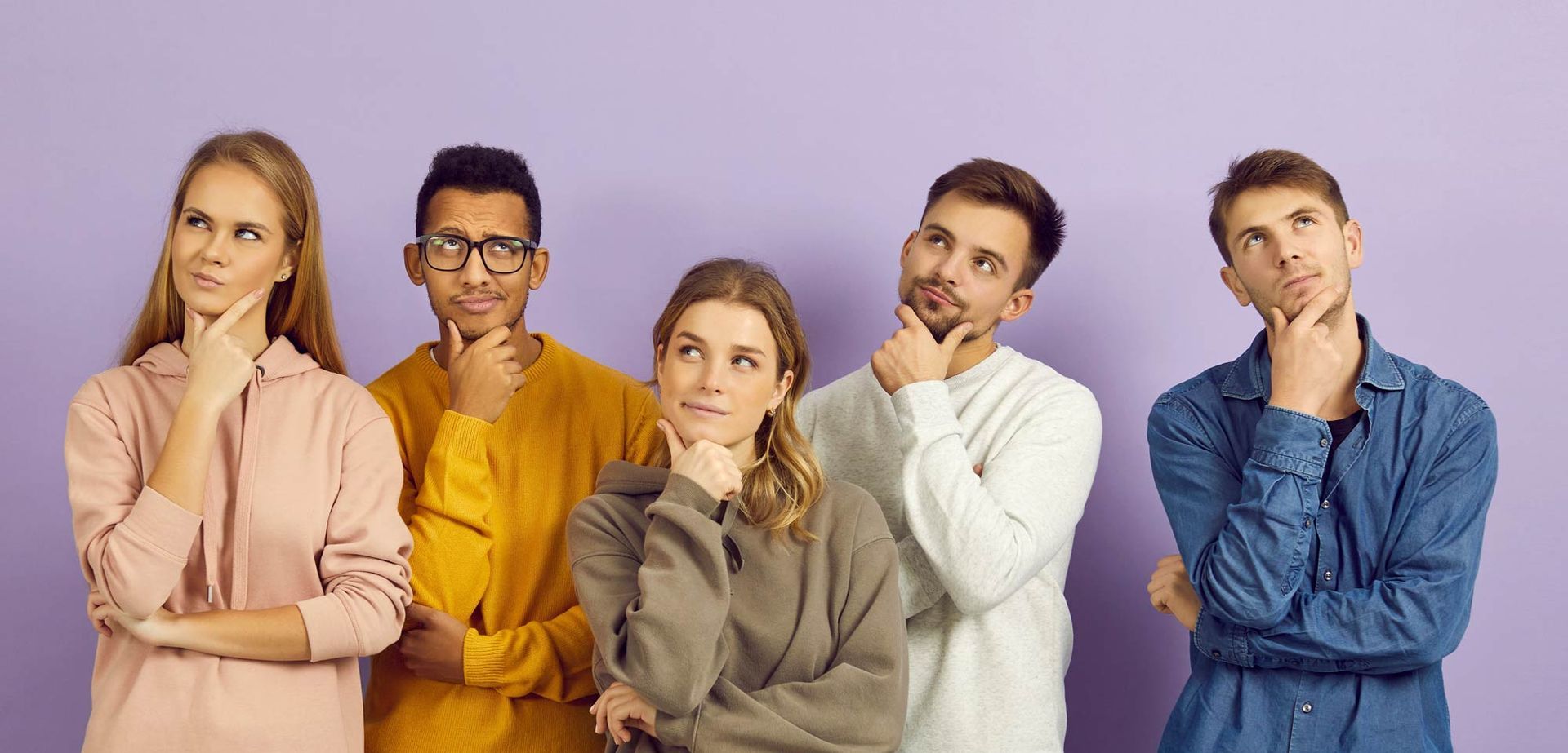 A group of students is standing next to each other with their hands on their chins