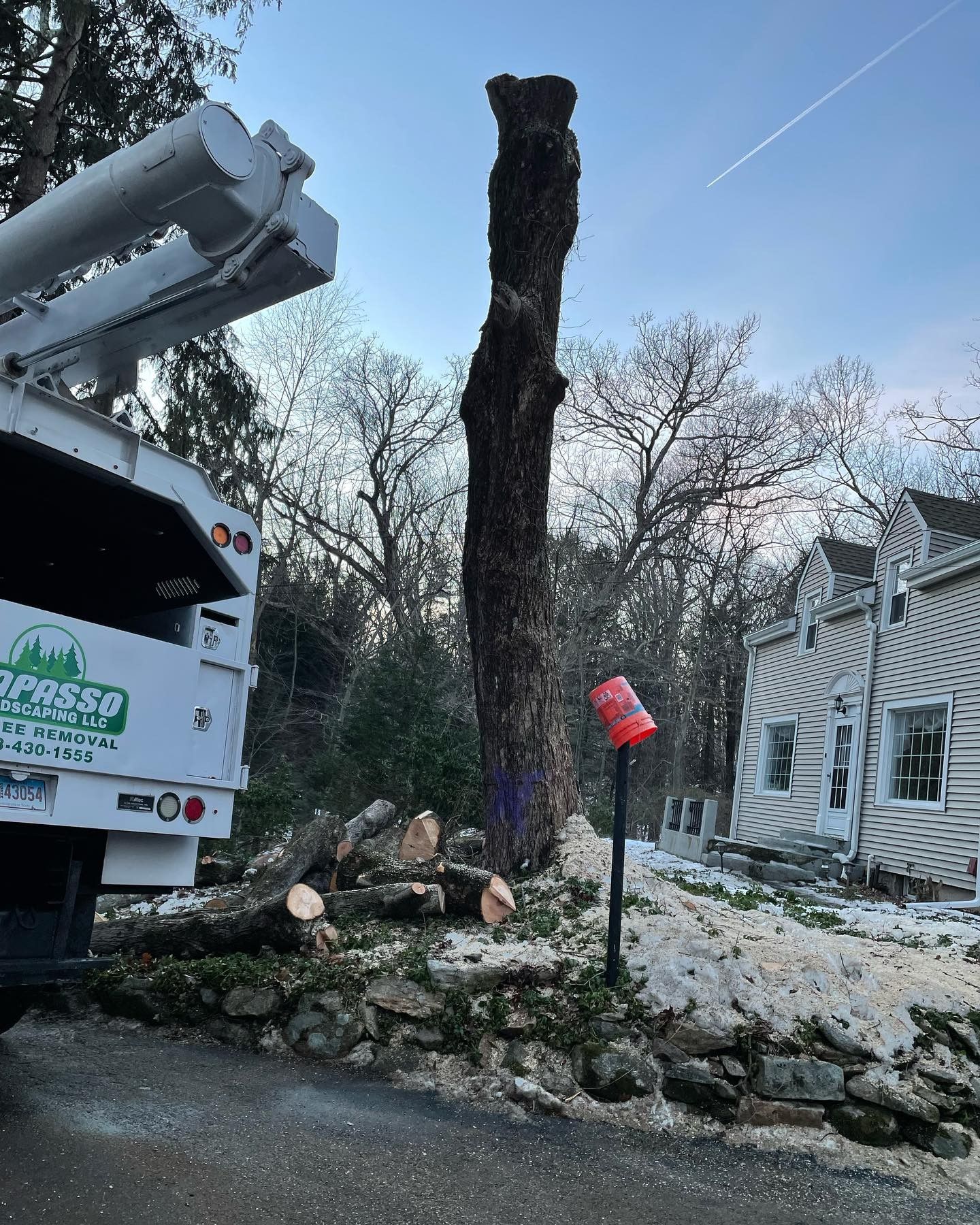 A tree stump is being removed by a truck.