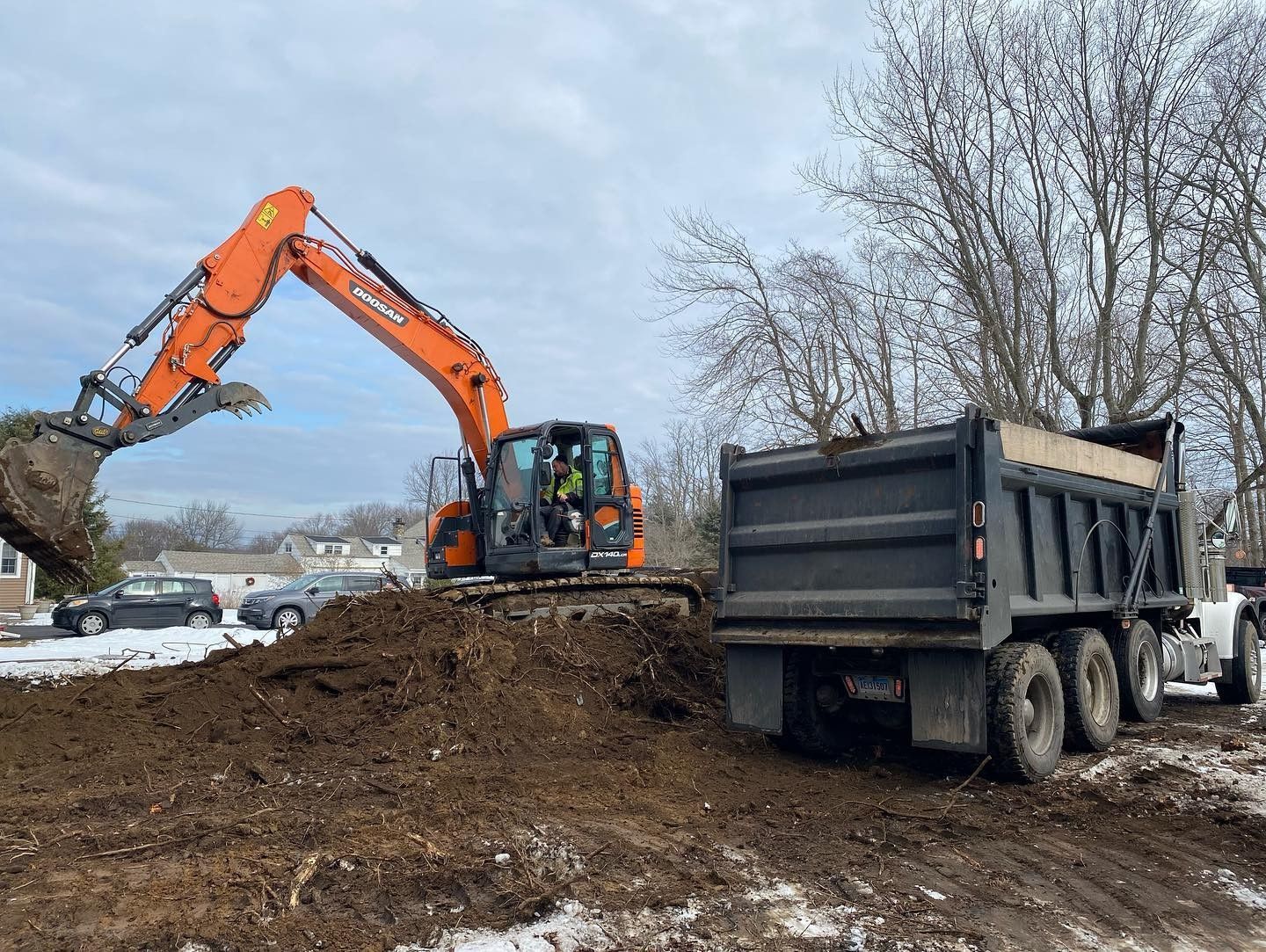 An excavator is loading dirt into a dump truck.
