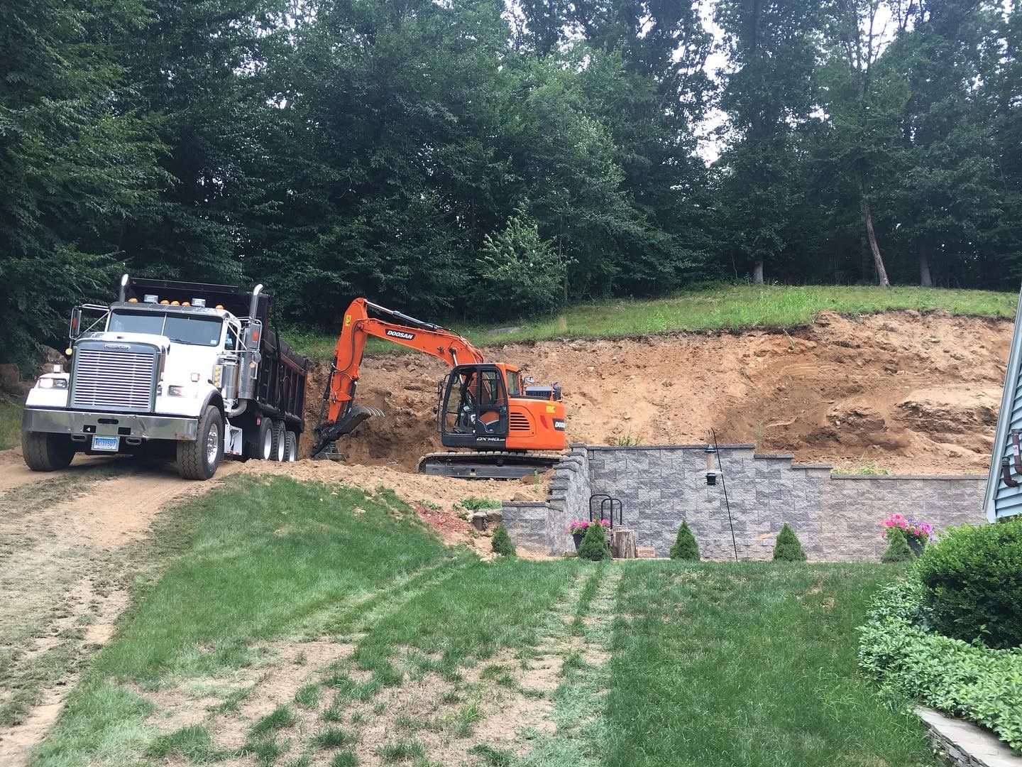 A truck is parked next to an excavator.