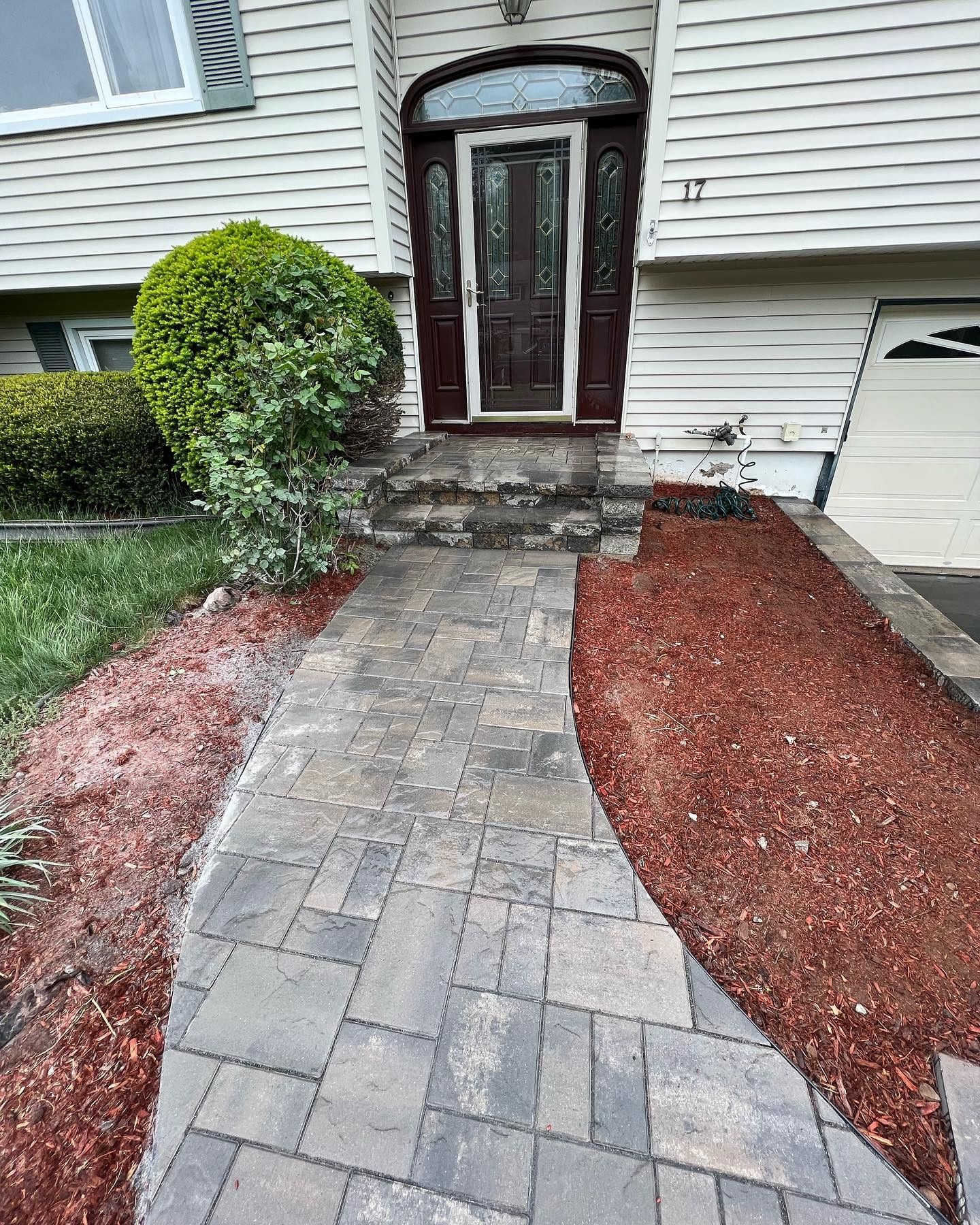 A brick walkway leading to the front door of a house.