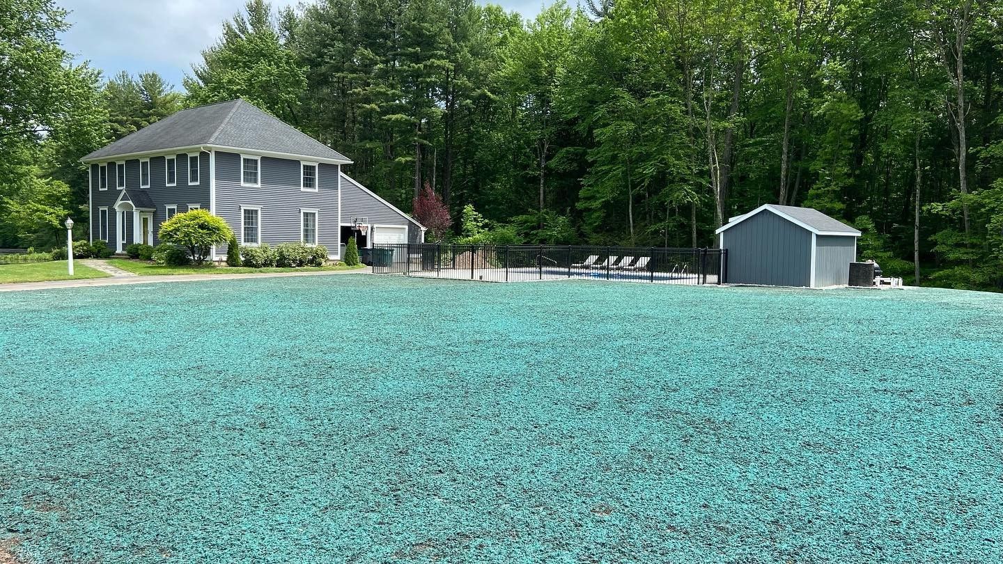 A large house is sitting on top of a lush green field.
