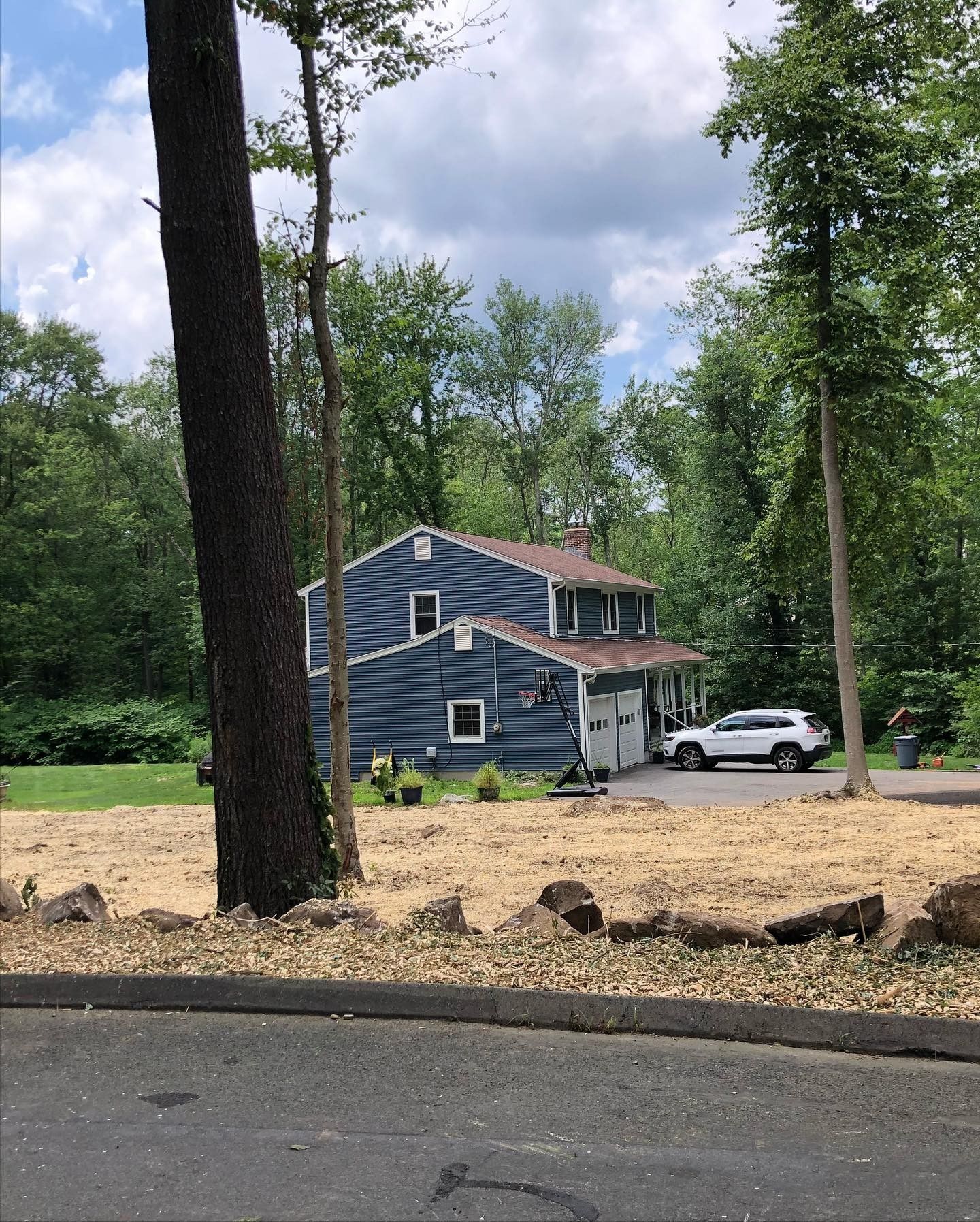 A blue house with a white suv parked in front of it