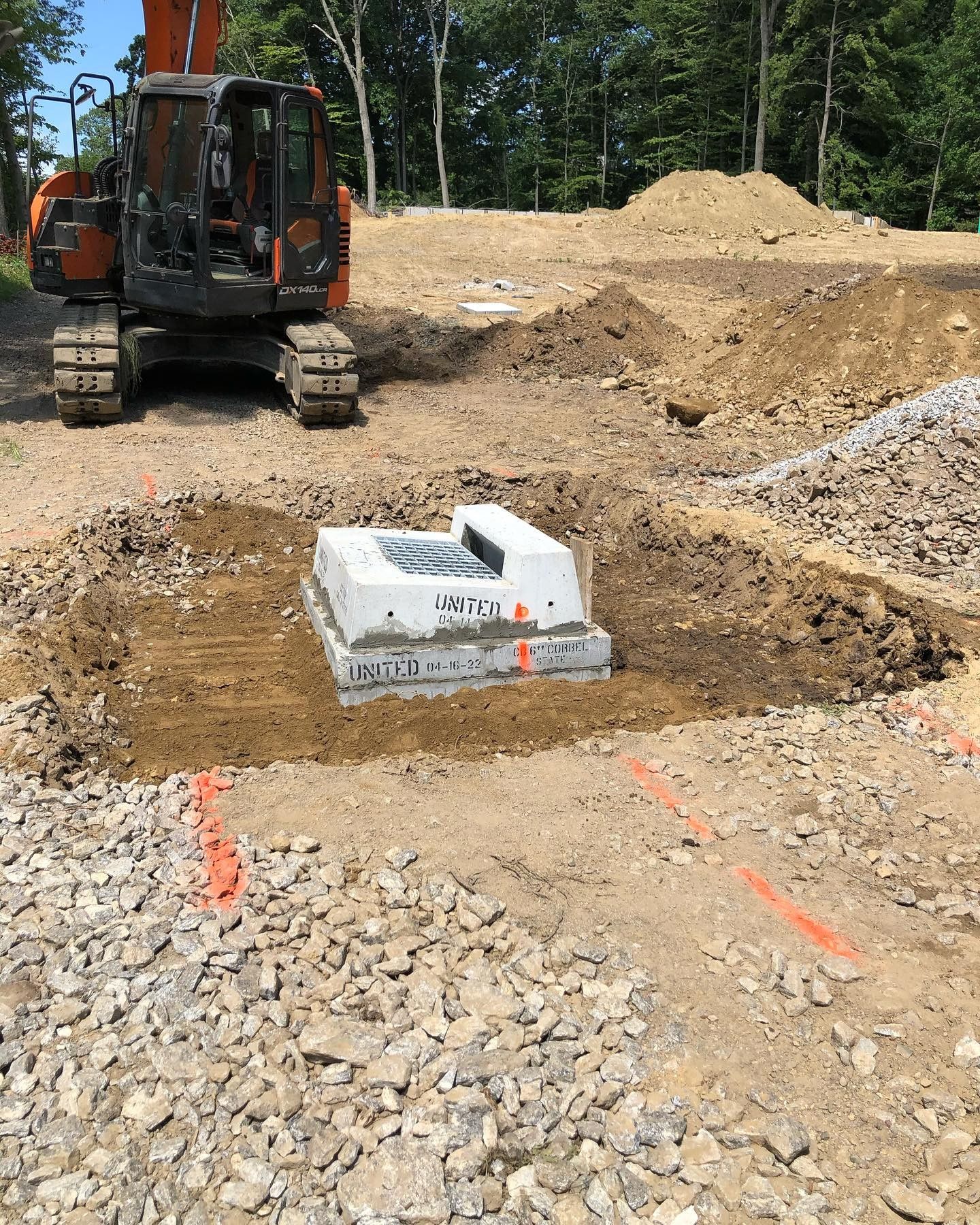 An excavator is digging a hole in the dirt in a construction site.