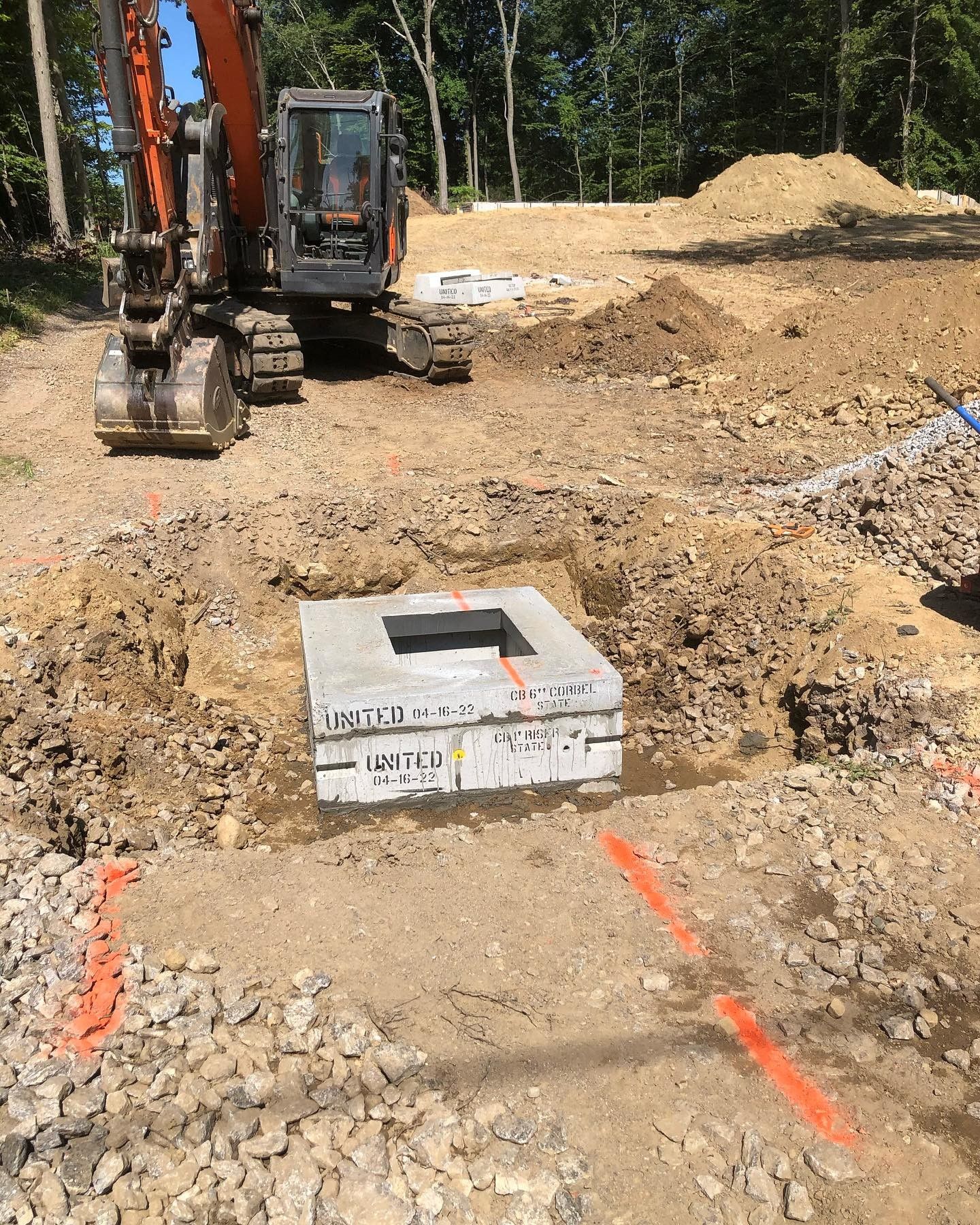 An excavator is digging a hole in the dirt in a construction site.
