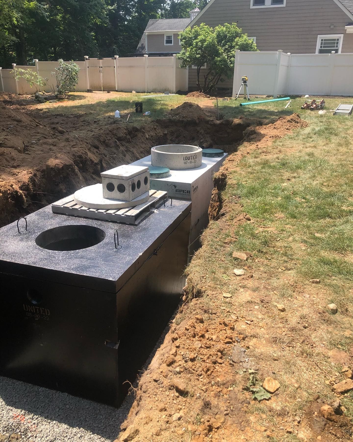 A septic tank is being built in the backyard of a house.