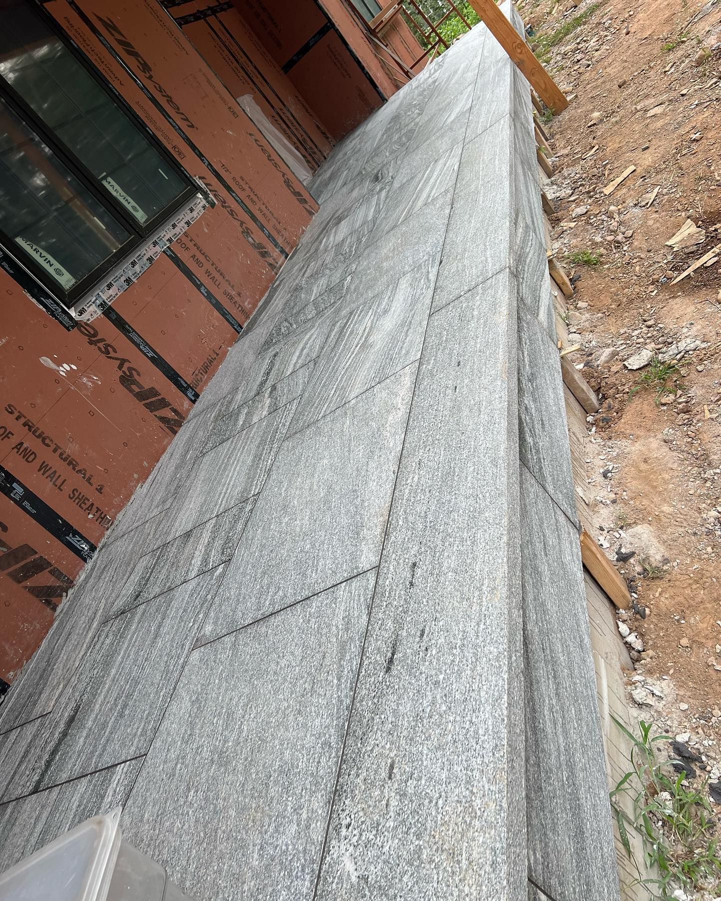 A brick wall is being built on the side of a building.