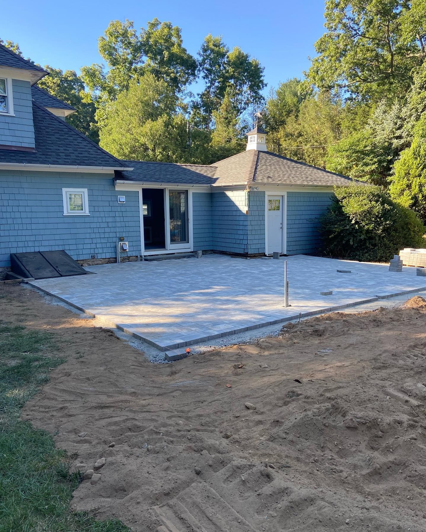 A blue house with a concrete patio in front of it.