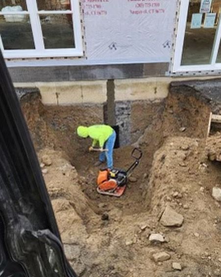A construction worker is digging a hole in the ground.