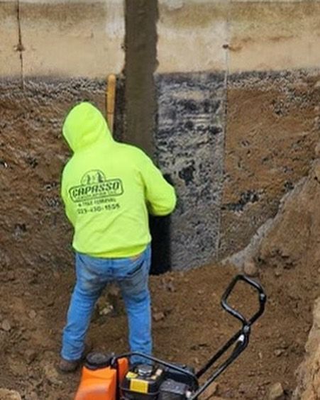 A man in a neon yellow hoodie is standing in the dirt