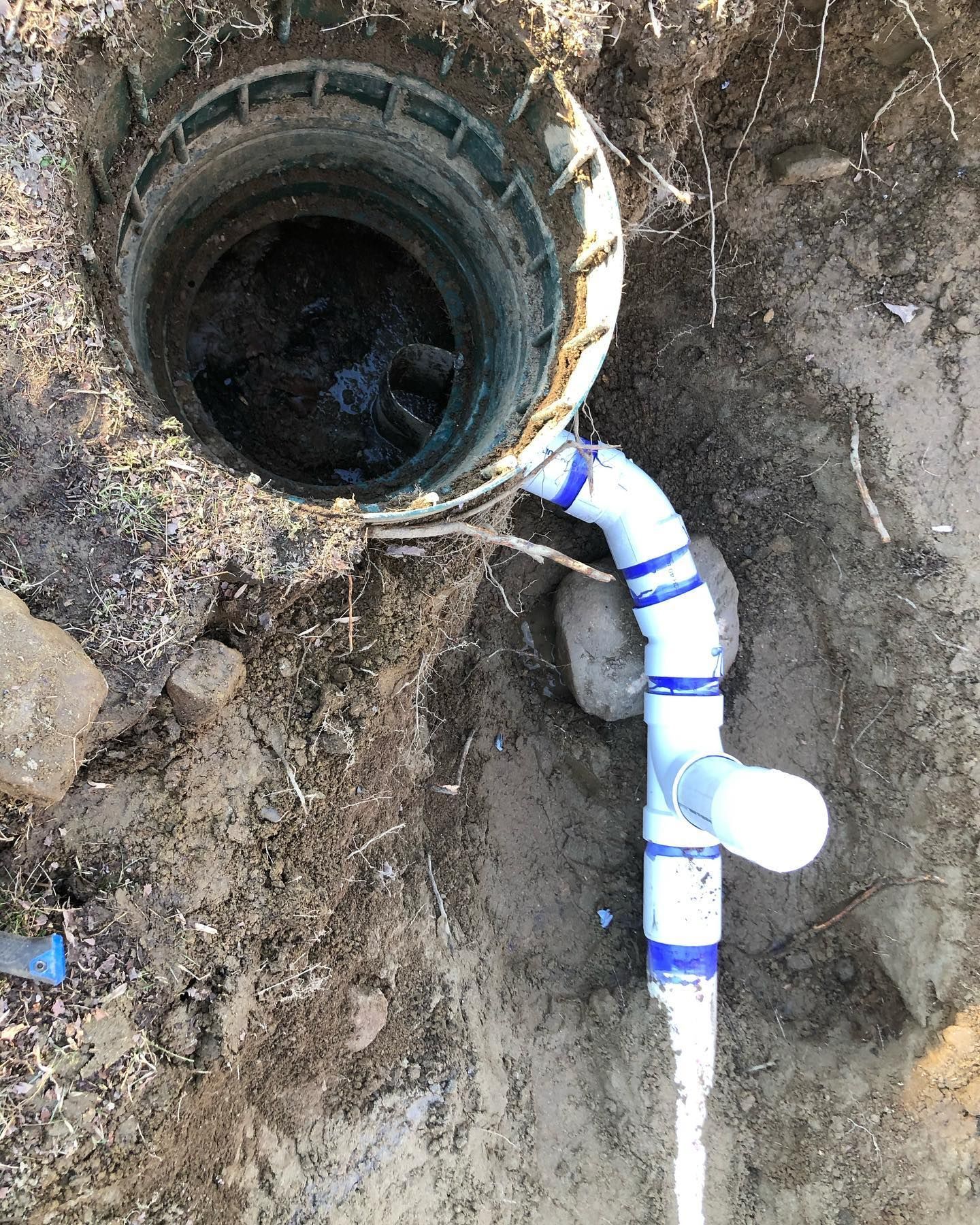 A hole in the ground with a pipe coming out of it.