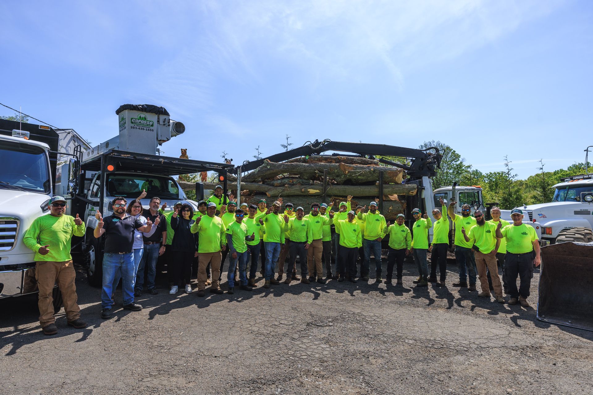 A group shot of the Capasso Landscaping crew standing in front of their service trucks