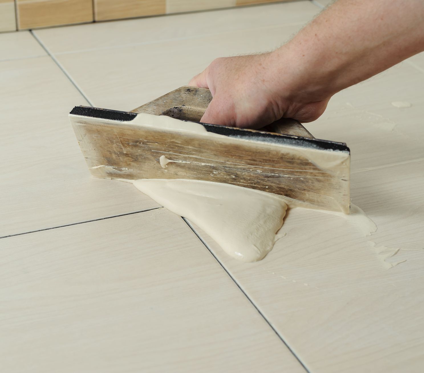applying grout on a tile floor