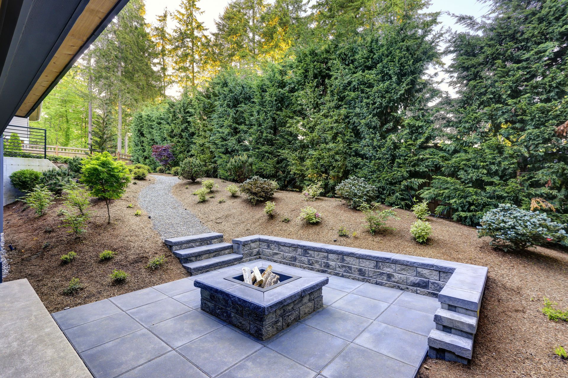a stone patio with a fire pit in the middle of it