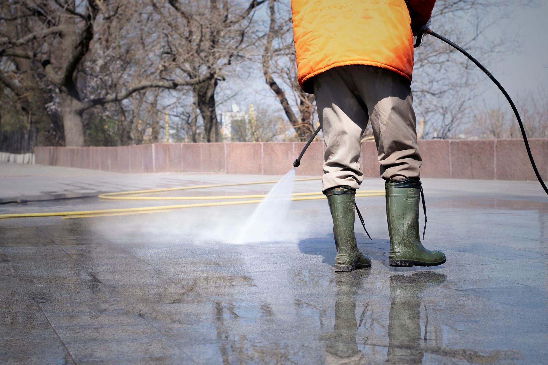 a man is using a high pressure washer to clean a concrete surface .
