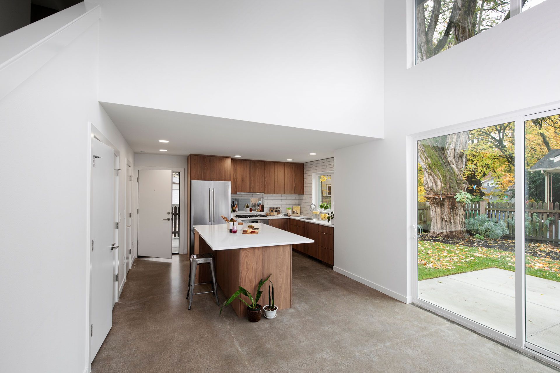 Modern open-plan kitchen and living area with large sliding glass doors and a view of the yard