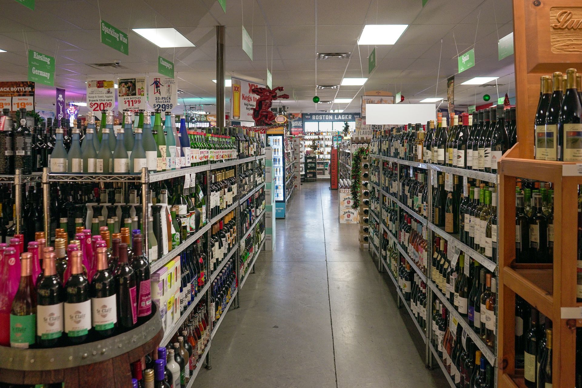 Rows of wine bottles line shelves in a well-lit liquor store.