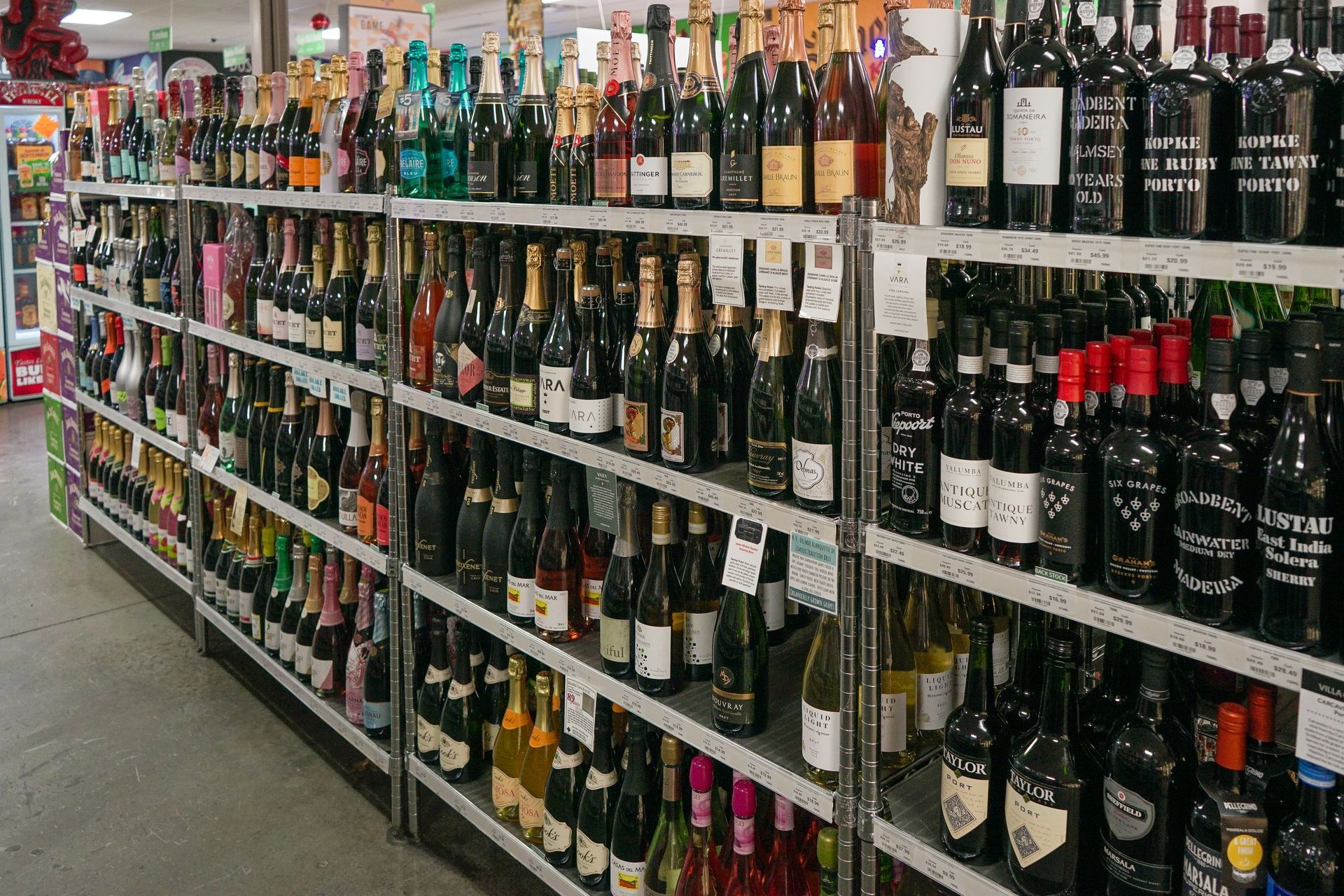 Shelves stocked with various wine bottles in a store setting.