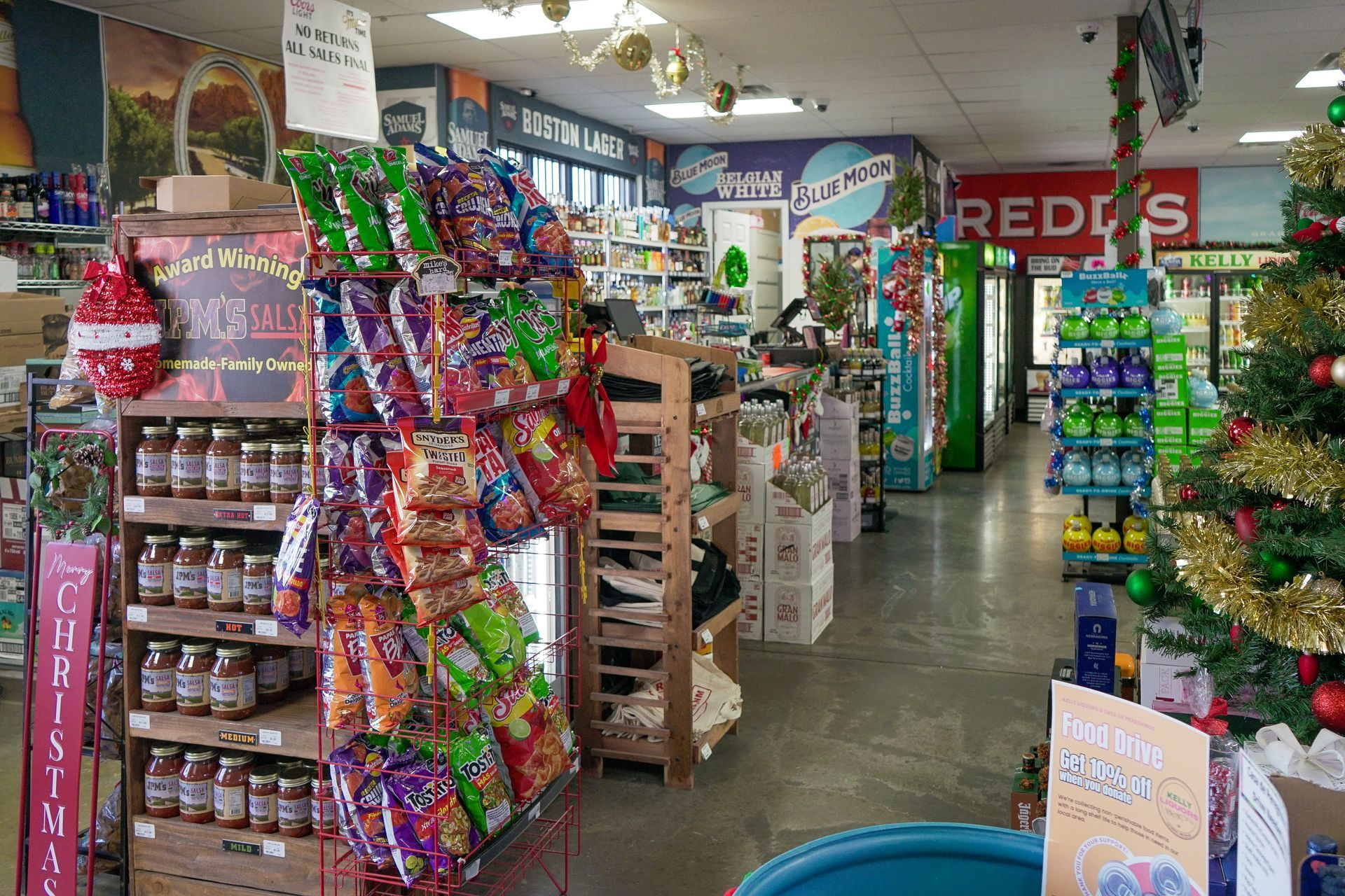 Inside a convenience store with shelves of snacks, and a Christmas tree.