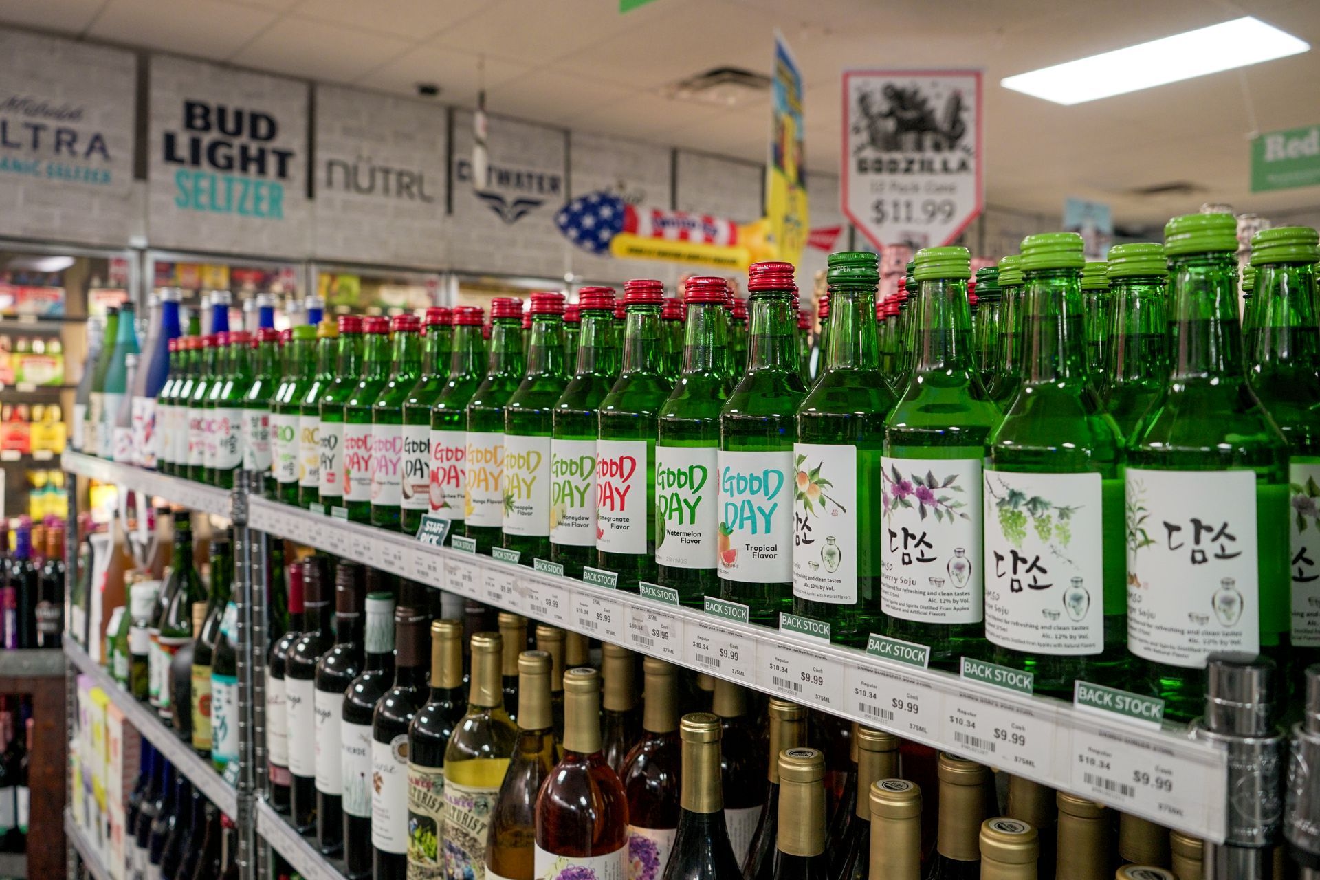 Shelves of green soju bottles and other alcohol in a liquor store.