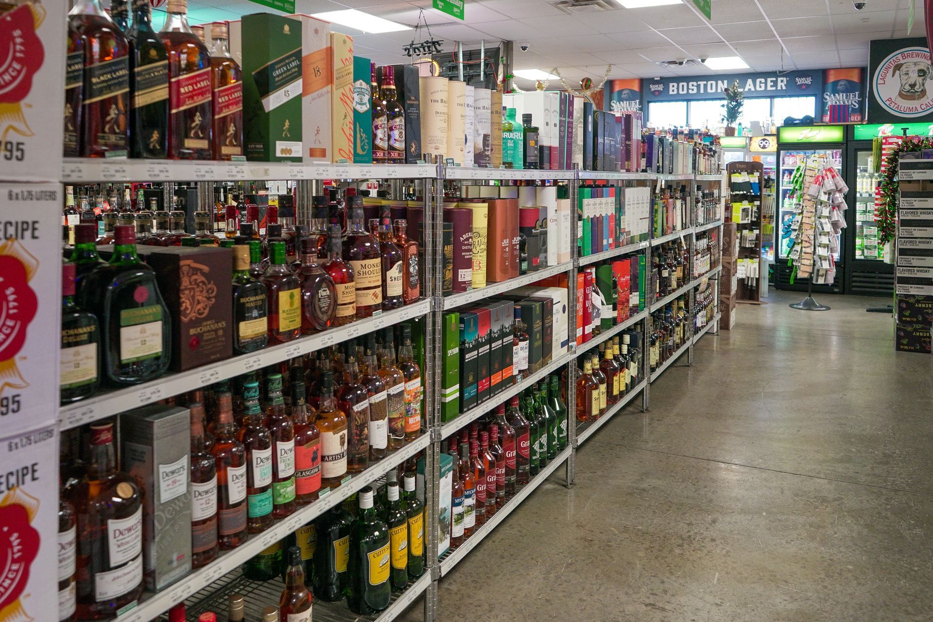 Shelves stocked with various liquor bottles inside a liquor store.
