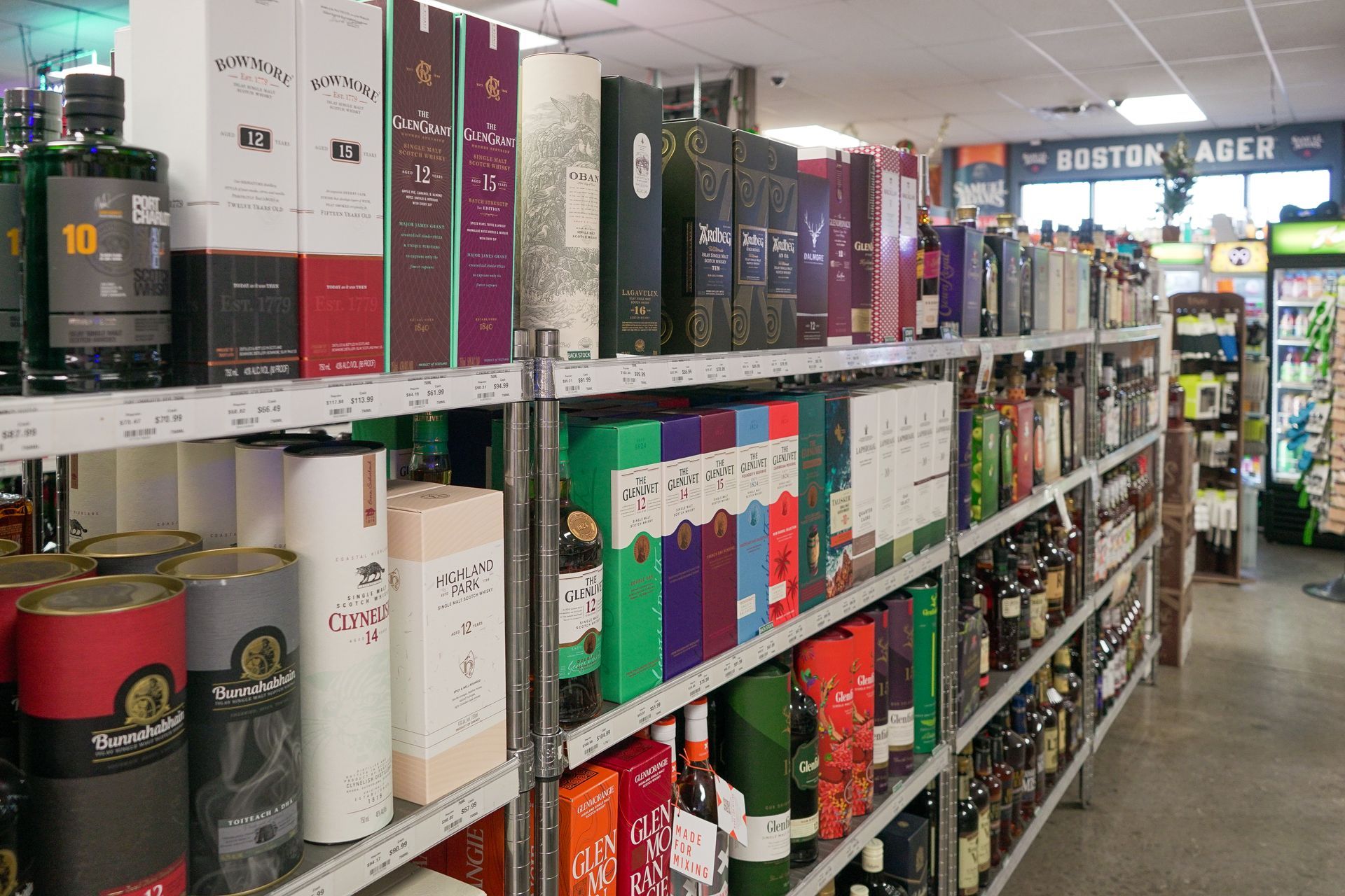 Shelves stocked with various liquor bottles and boxes in a store.