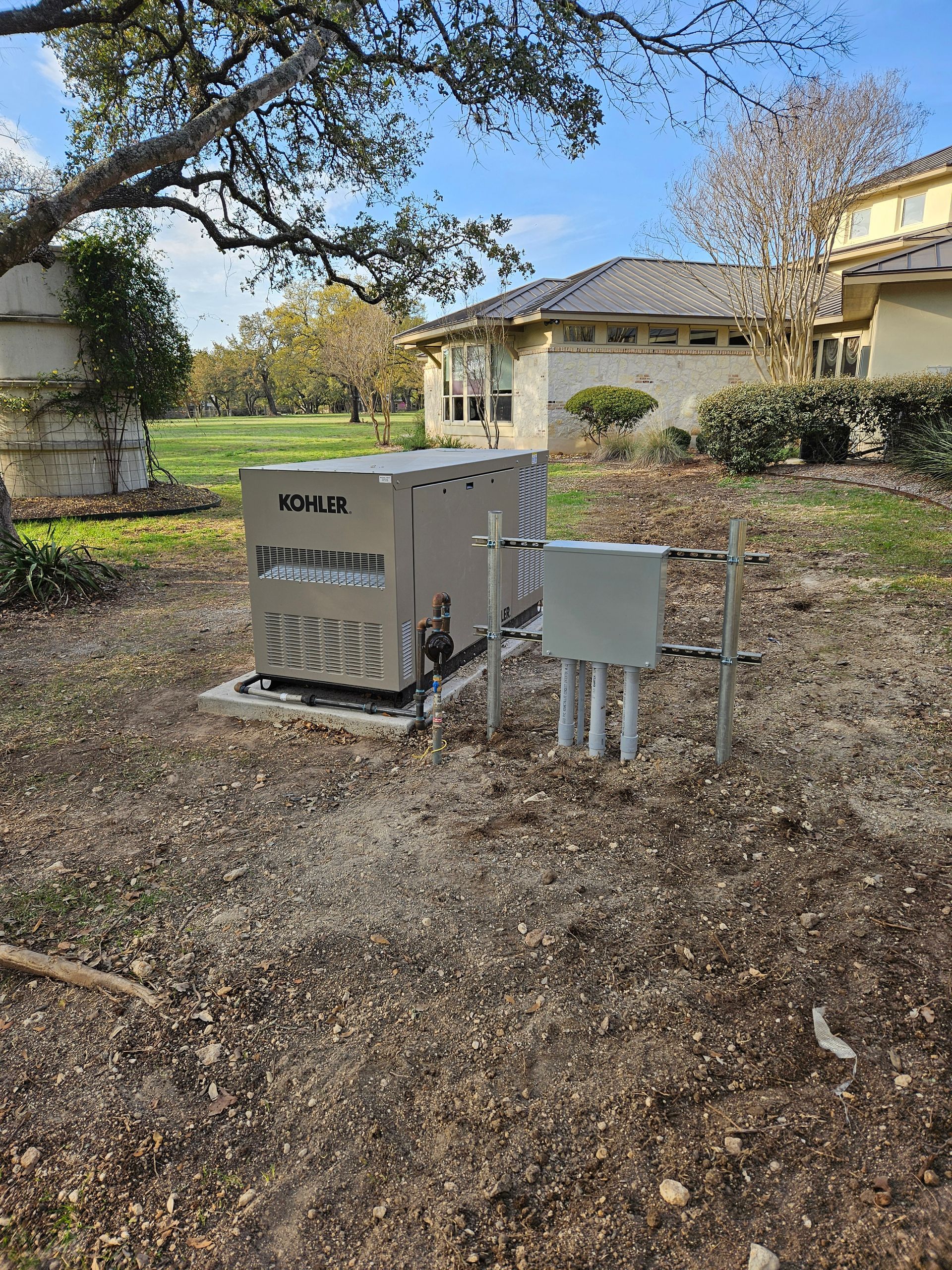 Generator unit on a concrete pad, in a grassy yard near a house.