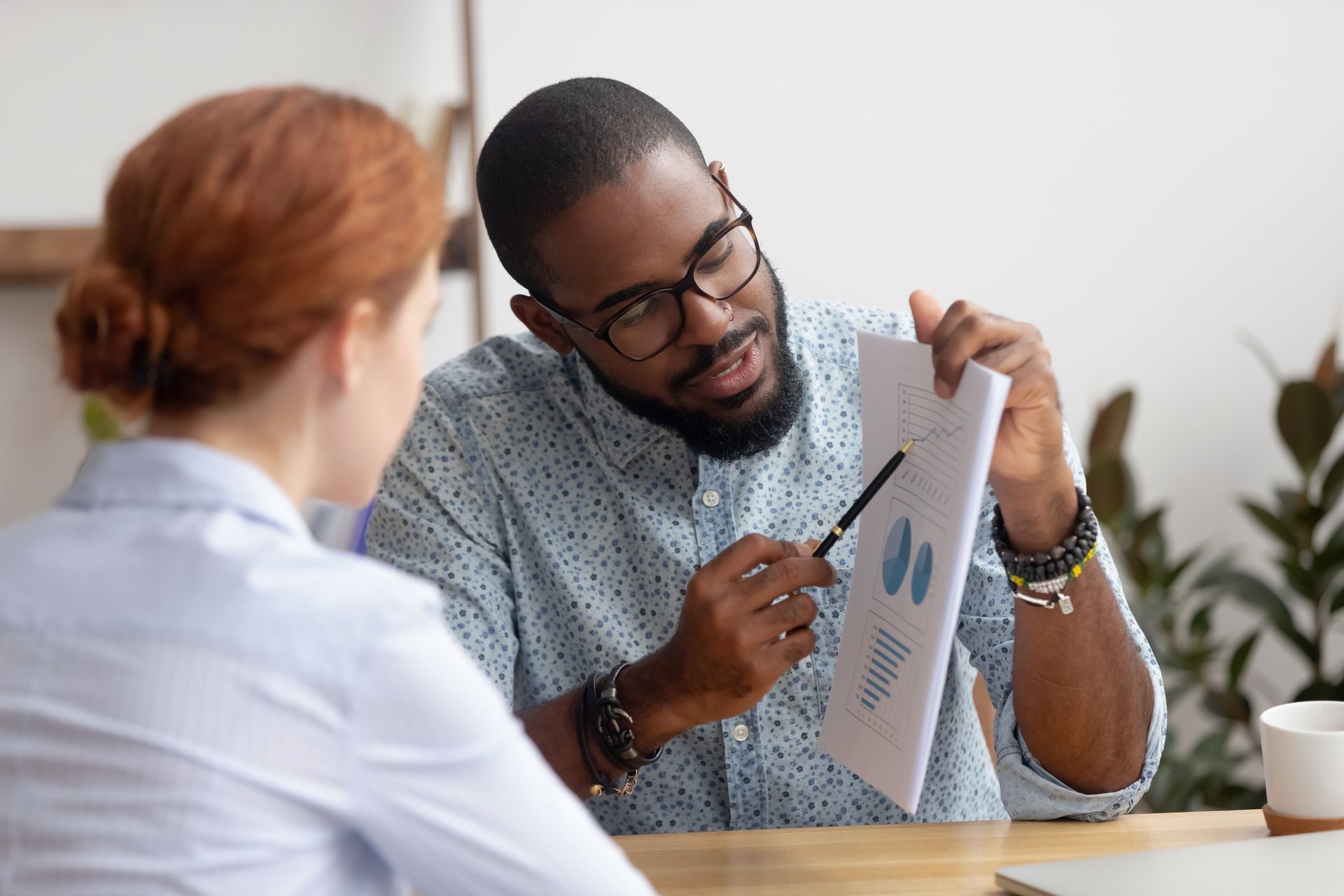 A man and a woman are sitting at a table looking at a piece of paper.